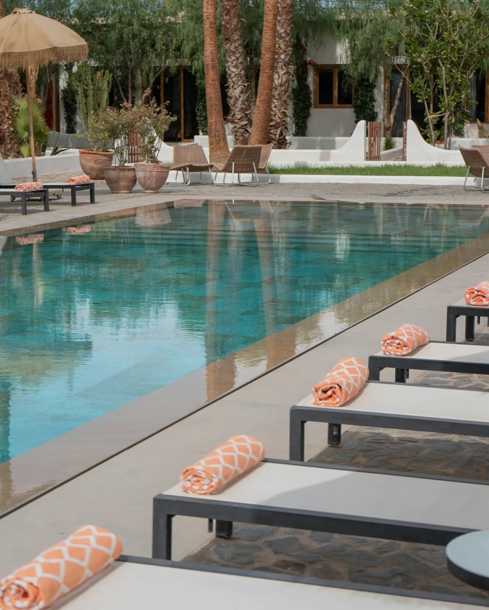 Pool edge lined with loungers and rolled towels