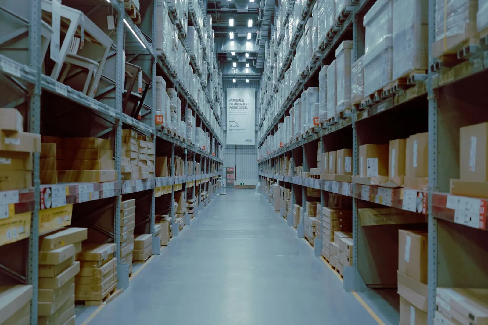 Long warehouse aisle lined with shelves of boxes